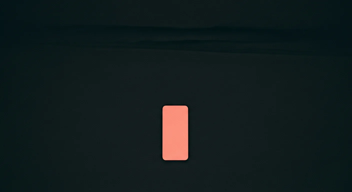 A smartphone glowing soft coral on a dark surface in a quiet, darkened bedroom at night.